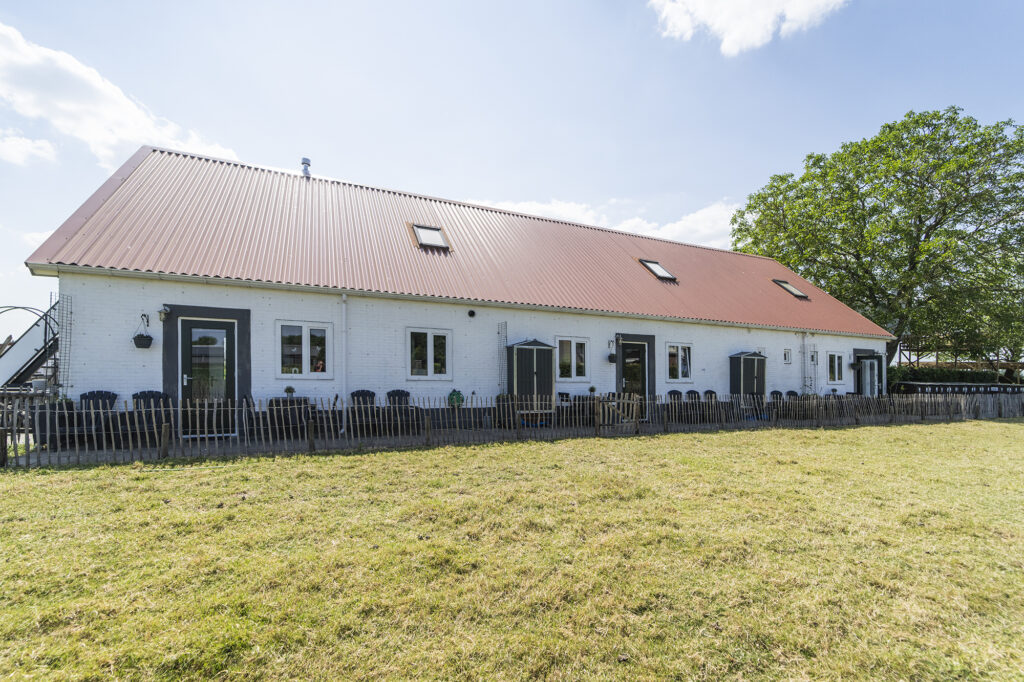 Witte boerderij met rood dak en grasveld, Boerderij de Zalm in Schalkwijk