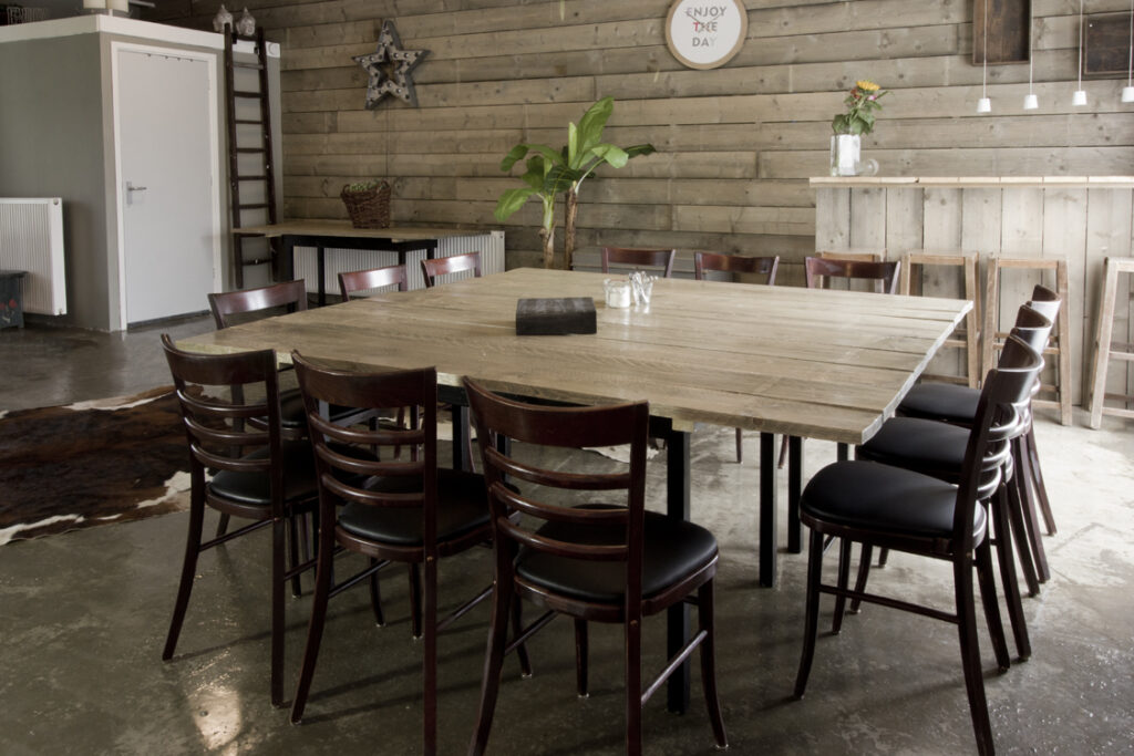Grote houten vergadertafel met stoelen in de Graanloft